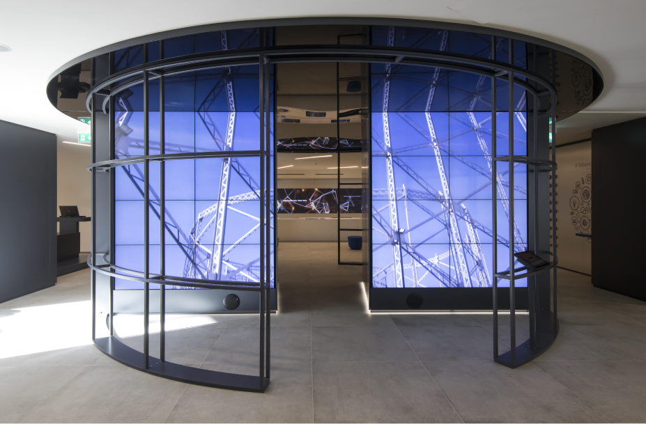 Heritage Lab di Italgas: interni moderni con schermi digitali che mostrano documenti storici digitalizzati.