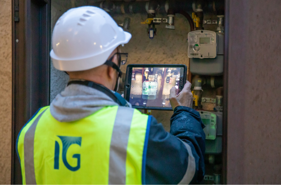 Operatore Italgas in giubbotto riflettente con tablet per digitalizzazione impianti.