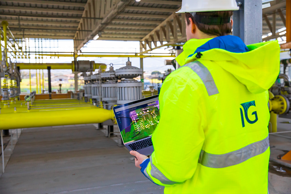 Operaio Italgas in tuta gialla effettua controlli in un capannone