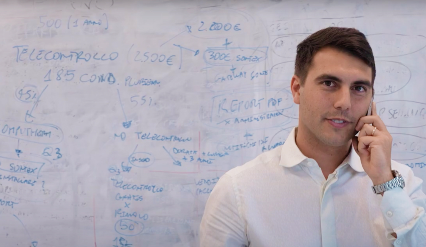 Uomo al telefono davanti a lavagna con grafici e note. Evidenzia brainstorming o lavoro di squadra in Italgas.