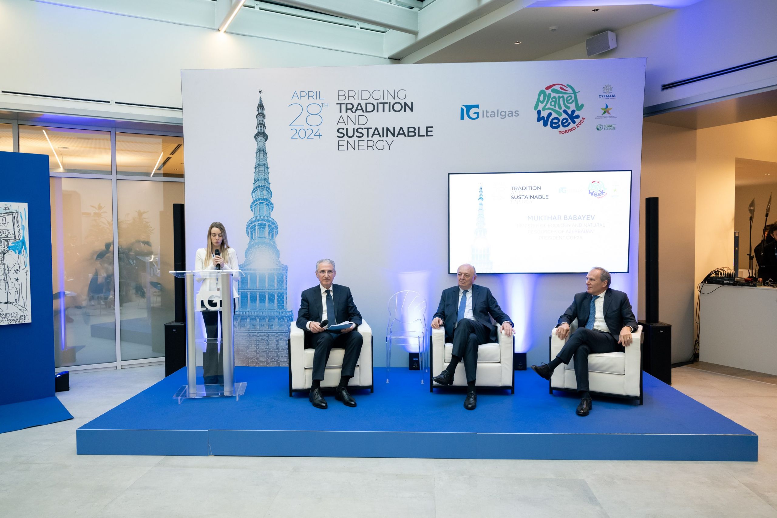 Evento Planet Week di Italgas: relatrice parla al podio, uomini seduti ascoltano.