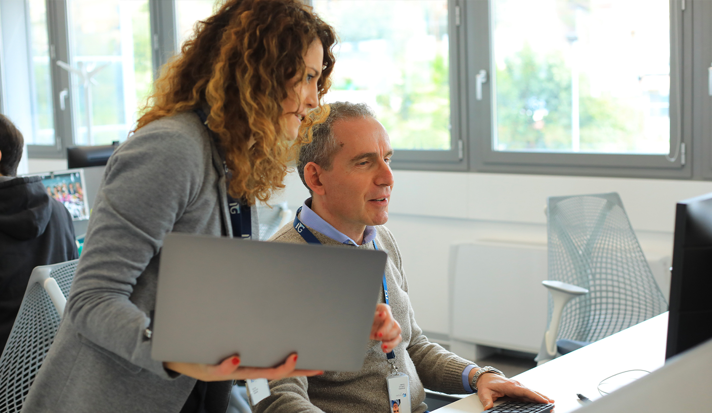Two Italgas colleagues work together on the computer, symbolizing training and collaboration in the IG Academy.