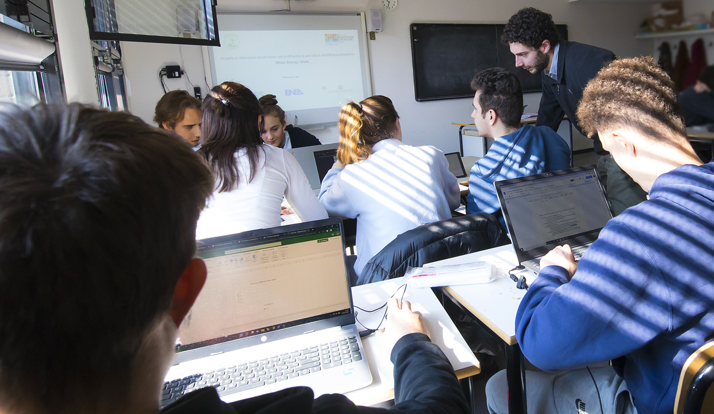 Italgas instructor with students and laptop during school educational project.
