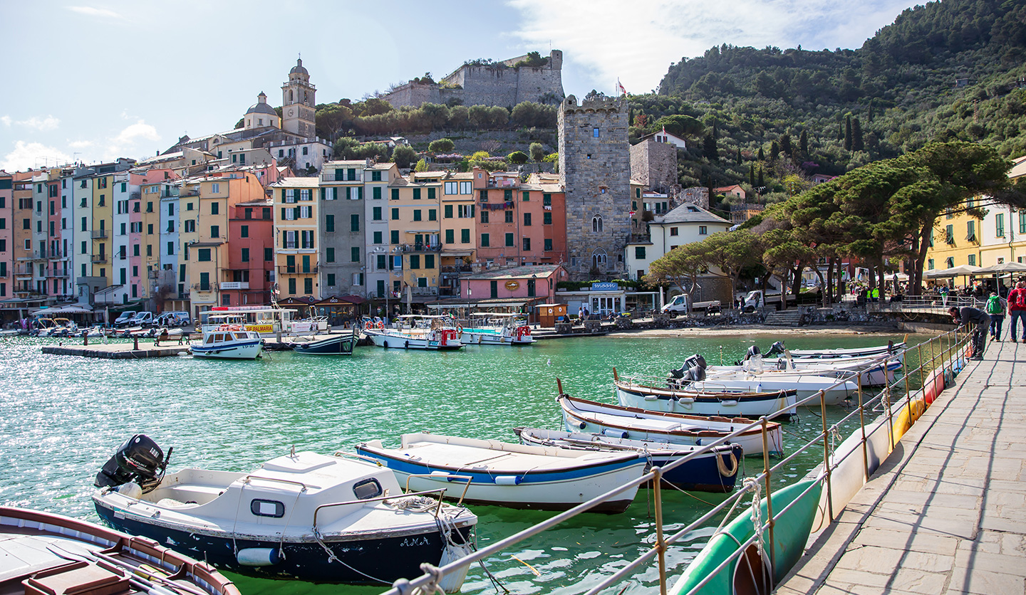 Image of Italgas: picturesque Italian port with boats and colorful urban houses in the background, a symbol of community growth.