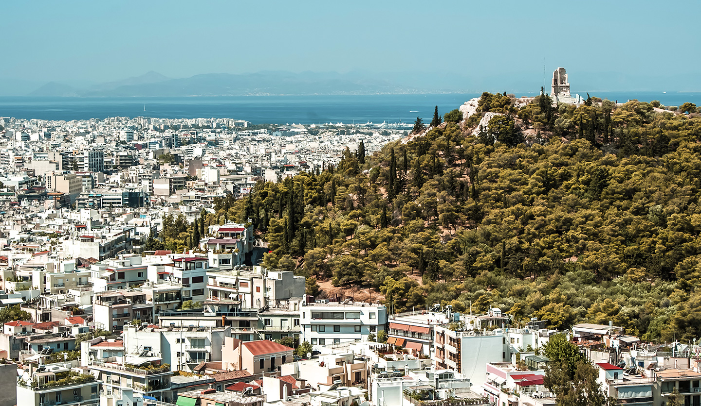 Panoramic view of a Greek city with greenery, connected to the Italgas sustainability project.
